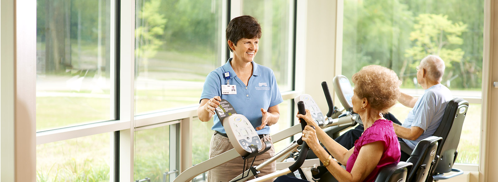 Wellness instructor with seniors on equipment at Mill Race Center