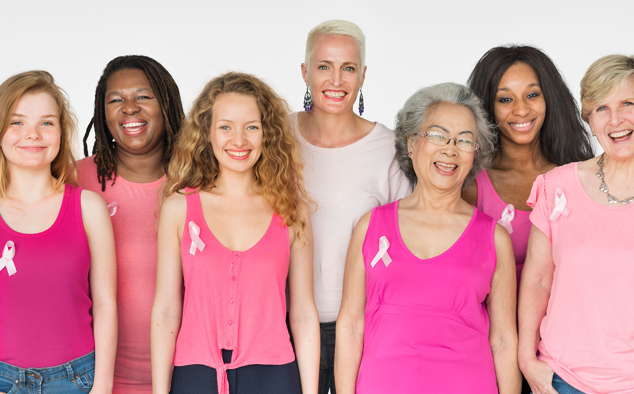 A group of diverse women dressed in pink.