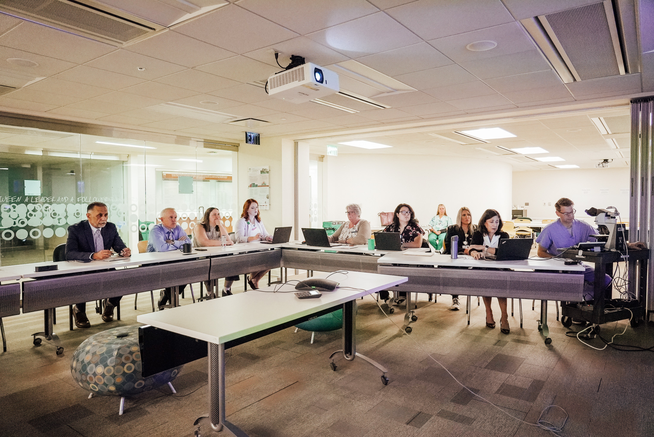 Group of doctors and clinicians meeting to discuss breast cancer cases.