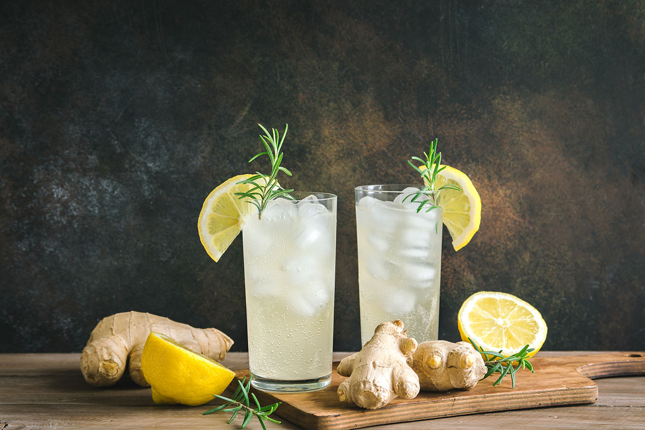 Two glasses with ice and citrus ginger fizz mocktail drink.