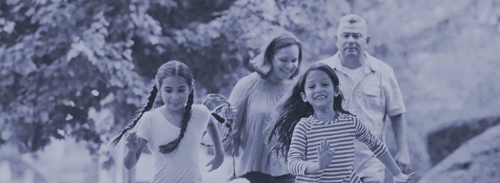 Parents and two young girls at a park.