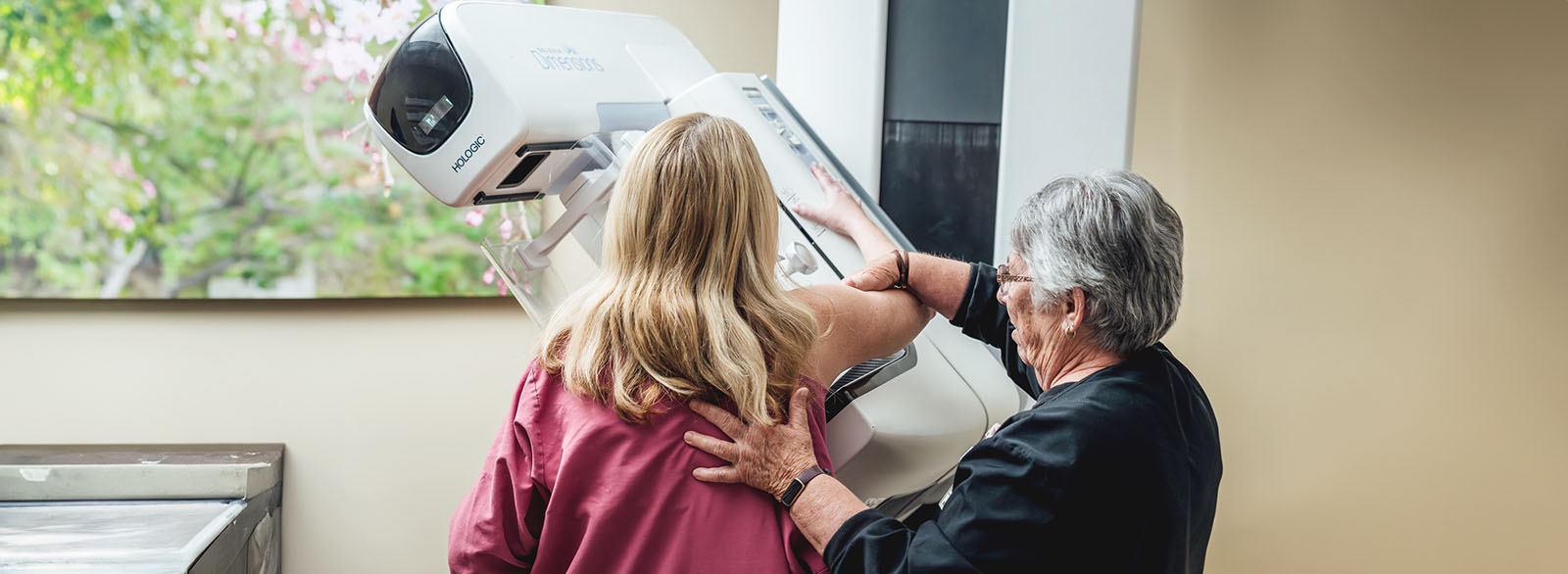 A Breast Health Center technician performs a mammogram on a patient.